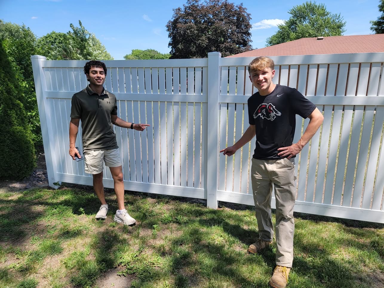 The Cypher Services team in front of a freshly cleaned vinyl fence